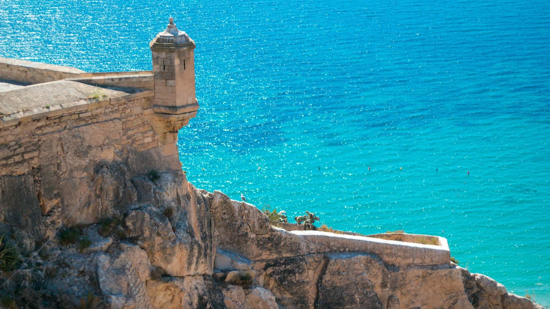 Garita de vigilancia de un castillo costero español sobre el mar Mediterráneo turquesa